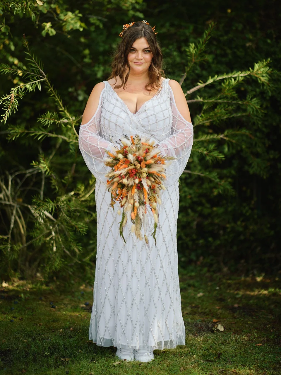 A bright bouquet held against the wedding dress
